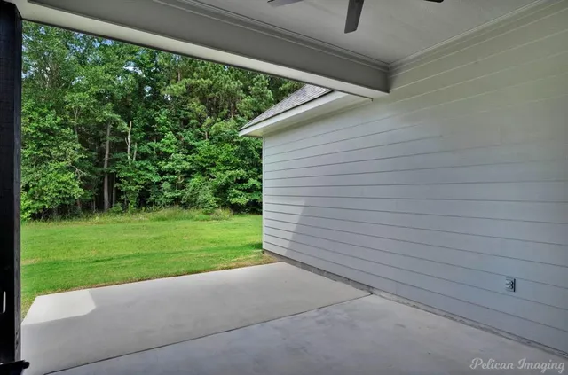 an empty room with a window and a ceiling fan