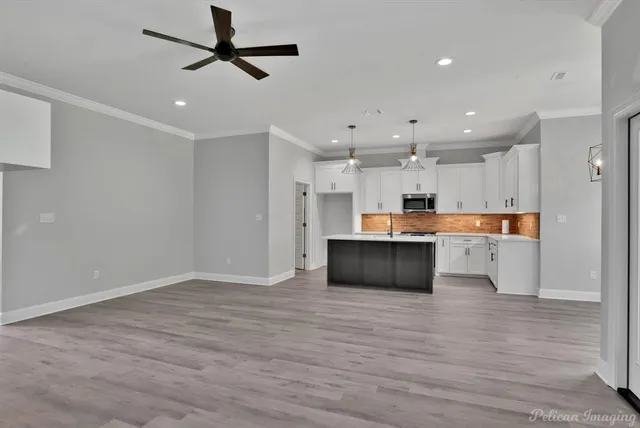 a view of a yard in front of a house with a large tree