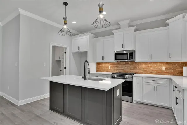 an empty room with wooden floor a ceiling fan a fireplace and windows