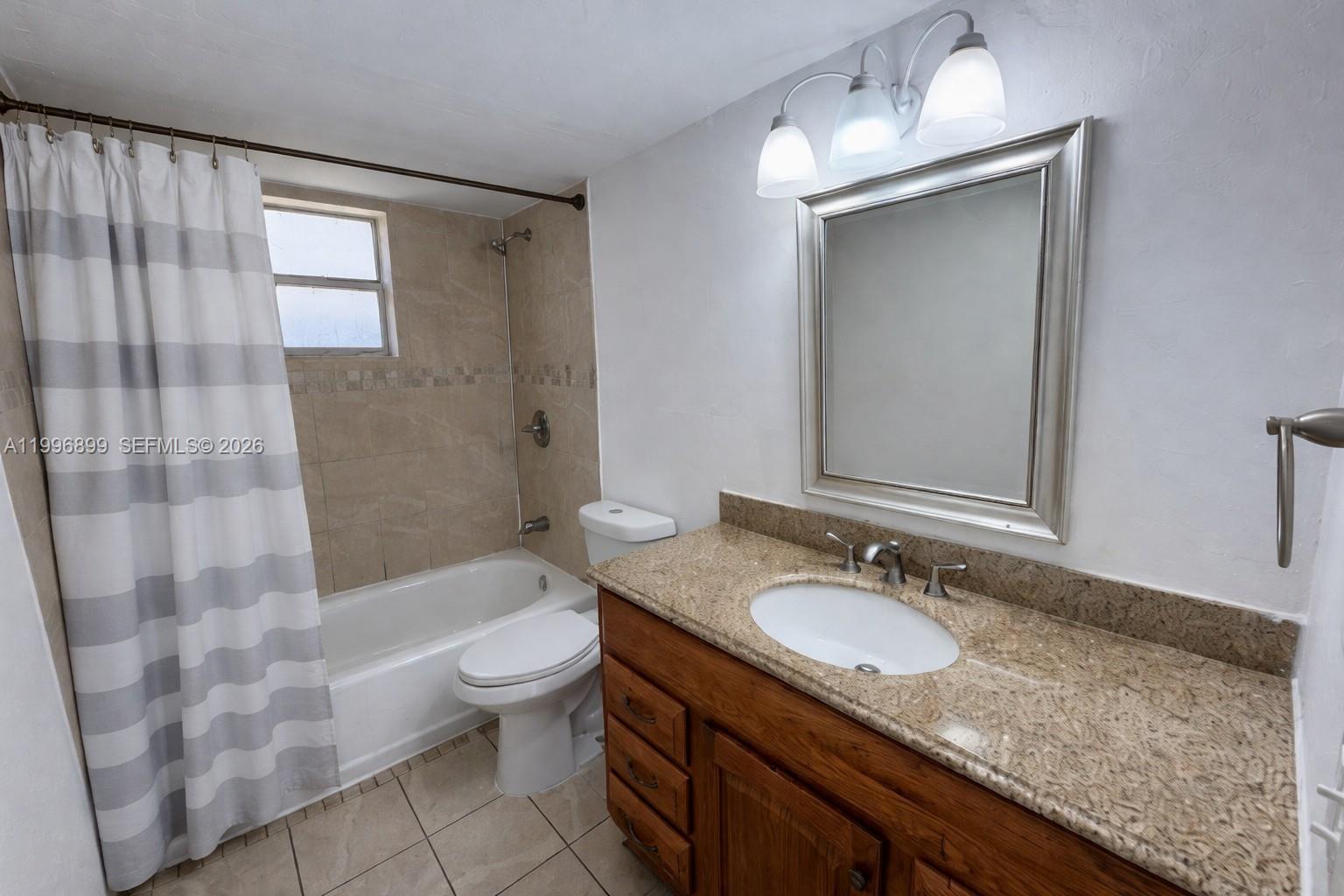 2521 Pierce Street, Unit 2 Hollywood, FL 33020 - Photo 4 of 11 a bathroom with a granite countertop sink toilet and shower