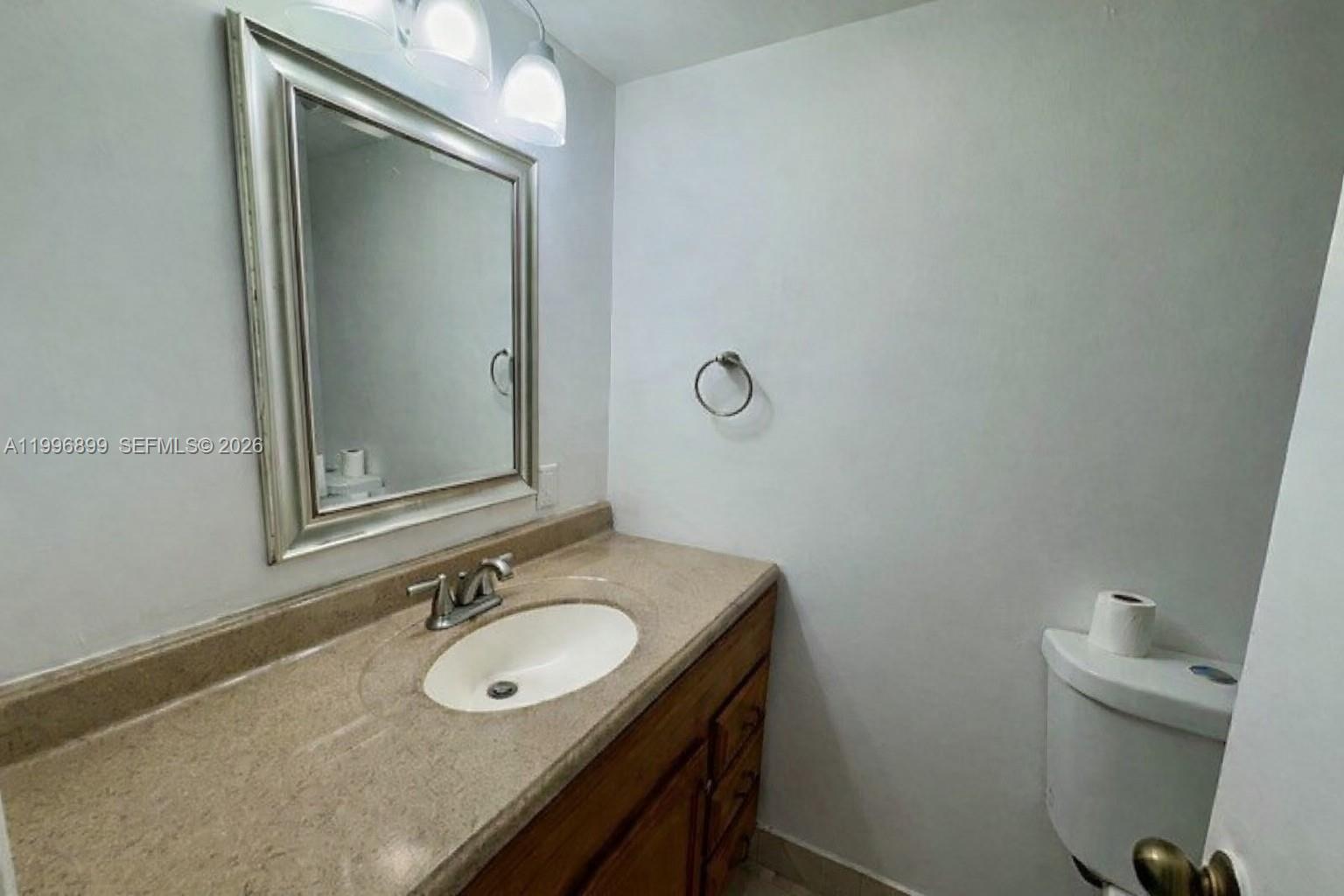 2521 Pierce Street, Unit 2 Hollywood, FL 33020 - Photo 7 of 11 a bathroom with a granite countertop sink and a mirror