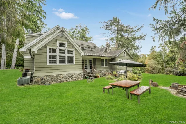 a front view of a house with a garden and trees