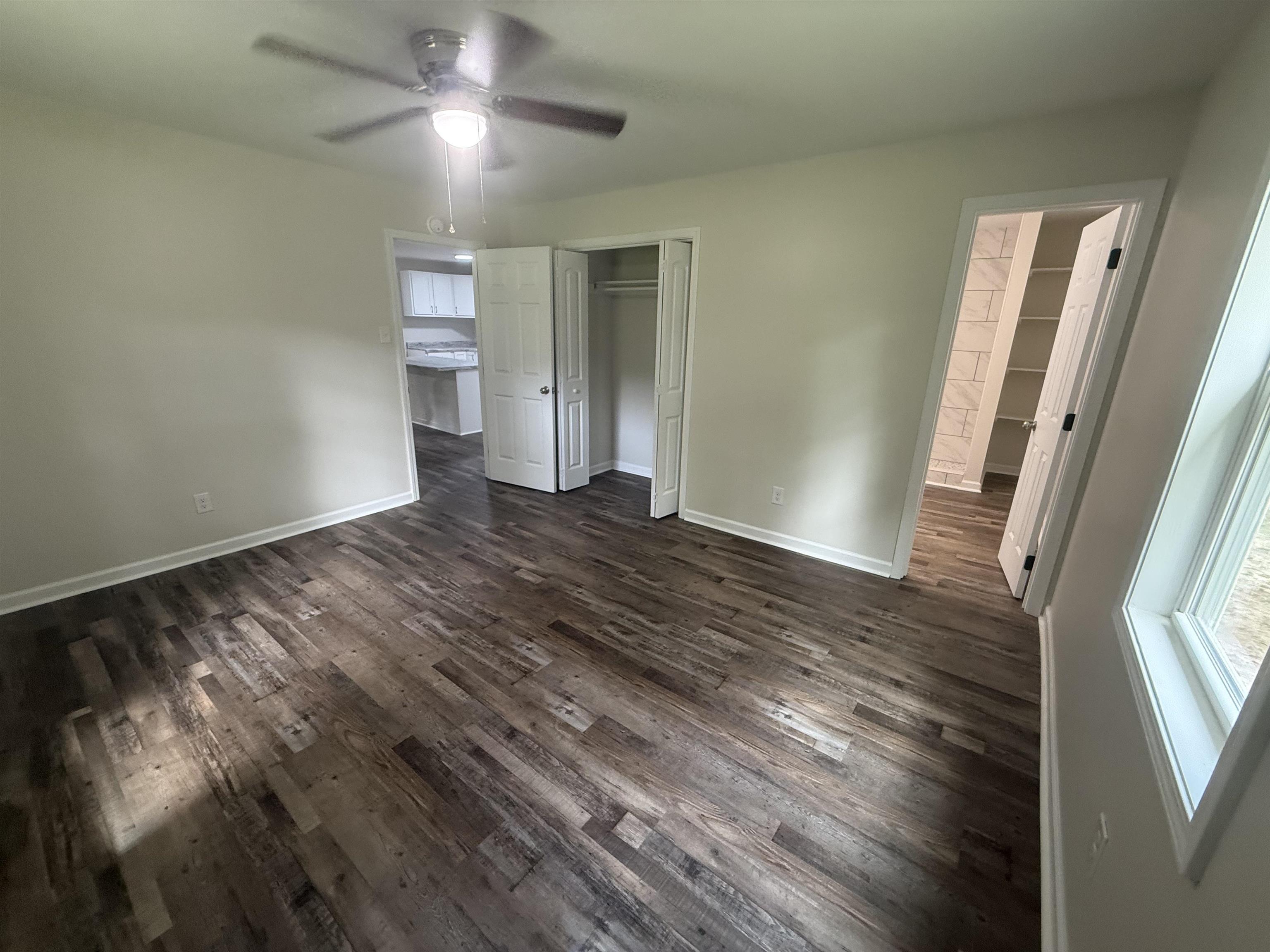195 Poole Road Moscow, TN 38057 - Photo 9 of 21 Spacious room featuring wood-finish flooring, light neutral walls, and a ceiling fan with integrated lighting