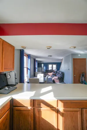 an empty room with wooden floor cabinet and windows