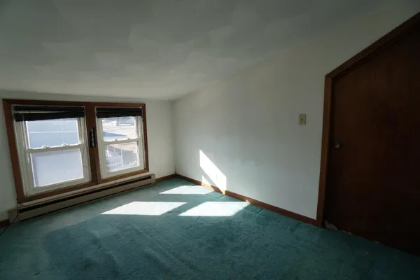 a view of water heater room with wooden floor