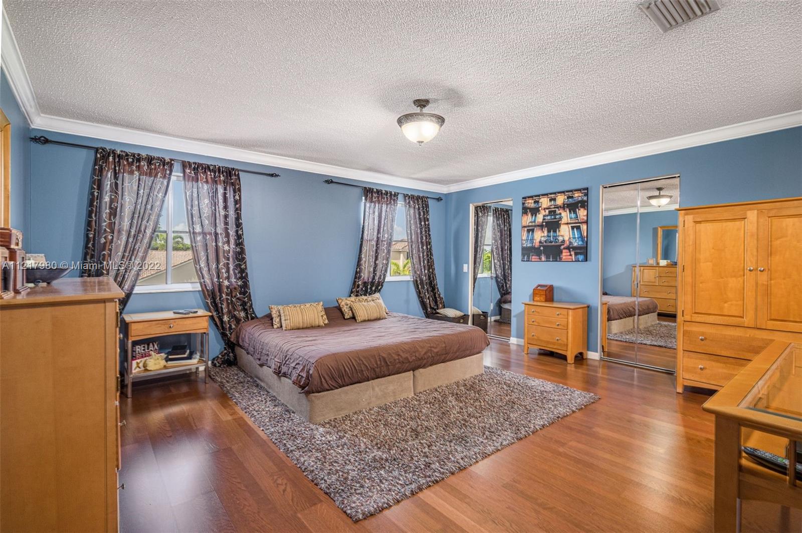 1418 Sandpiper Circle Weston, FL 33327 - Photo 14 of 31 a bedroom with a bed and wooden floor