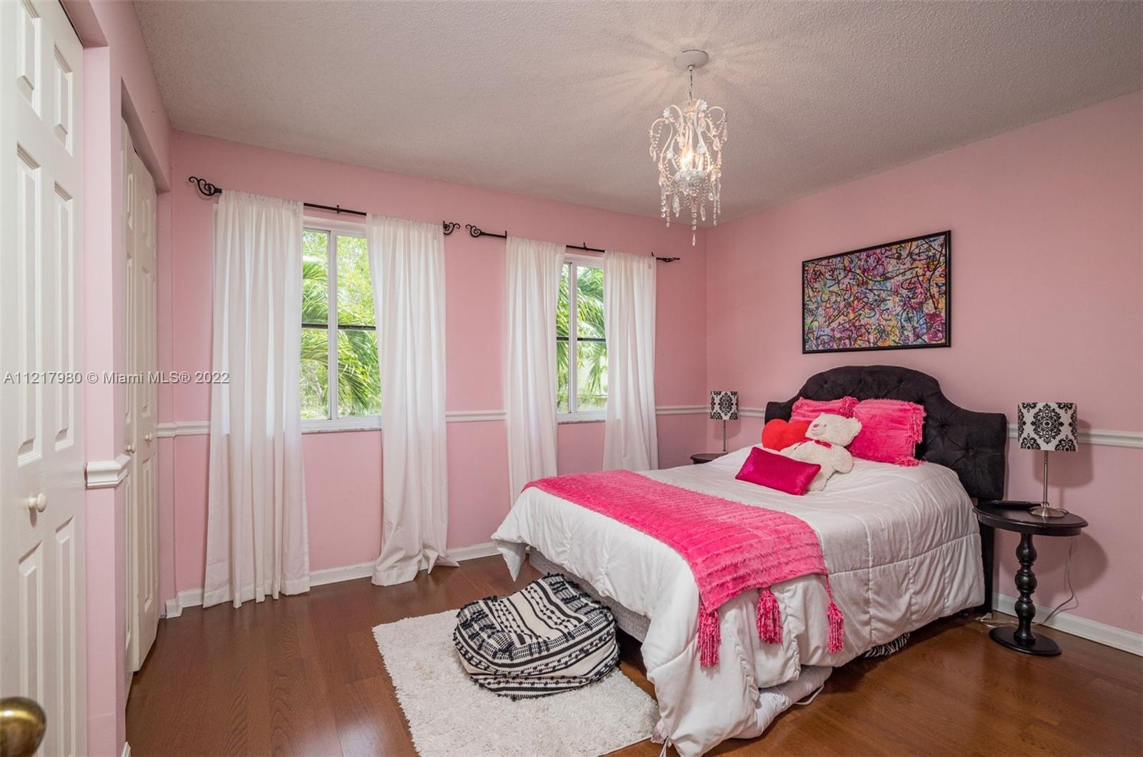 1418 Sandpiper Circle Weston, FL 33327 - Photo 21 of 31 a bedroom with a bed and a chandelier