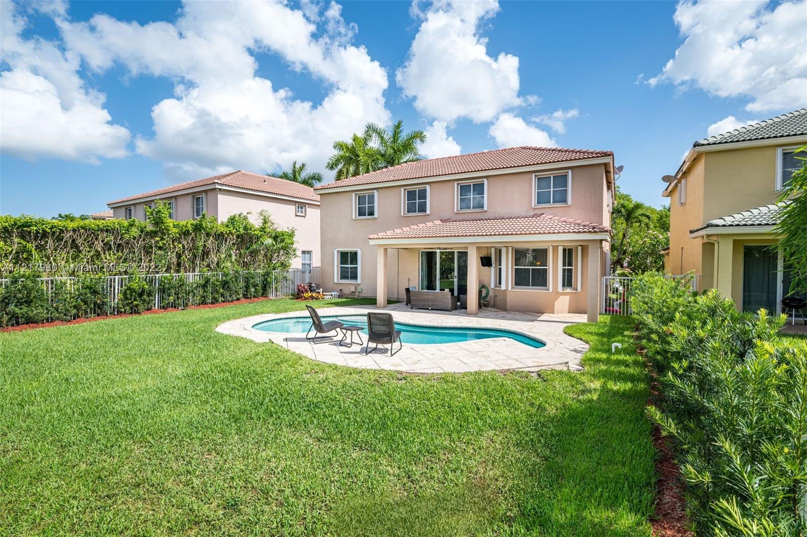 1418 Sandpiper Circle Weston, FL 33327 - Photo 26 of 31 a front view of a house with a yard table and chairs