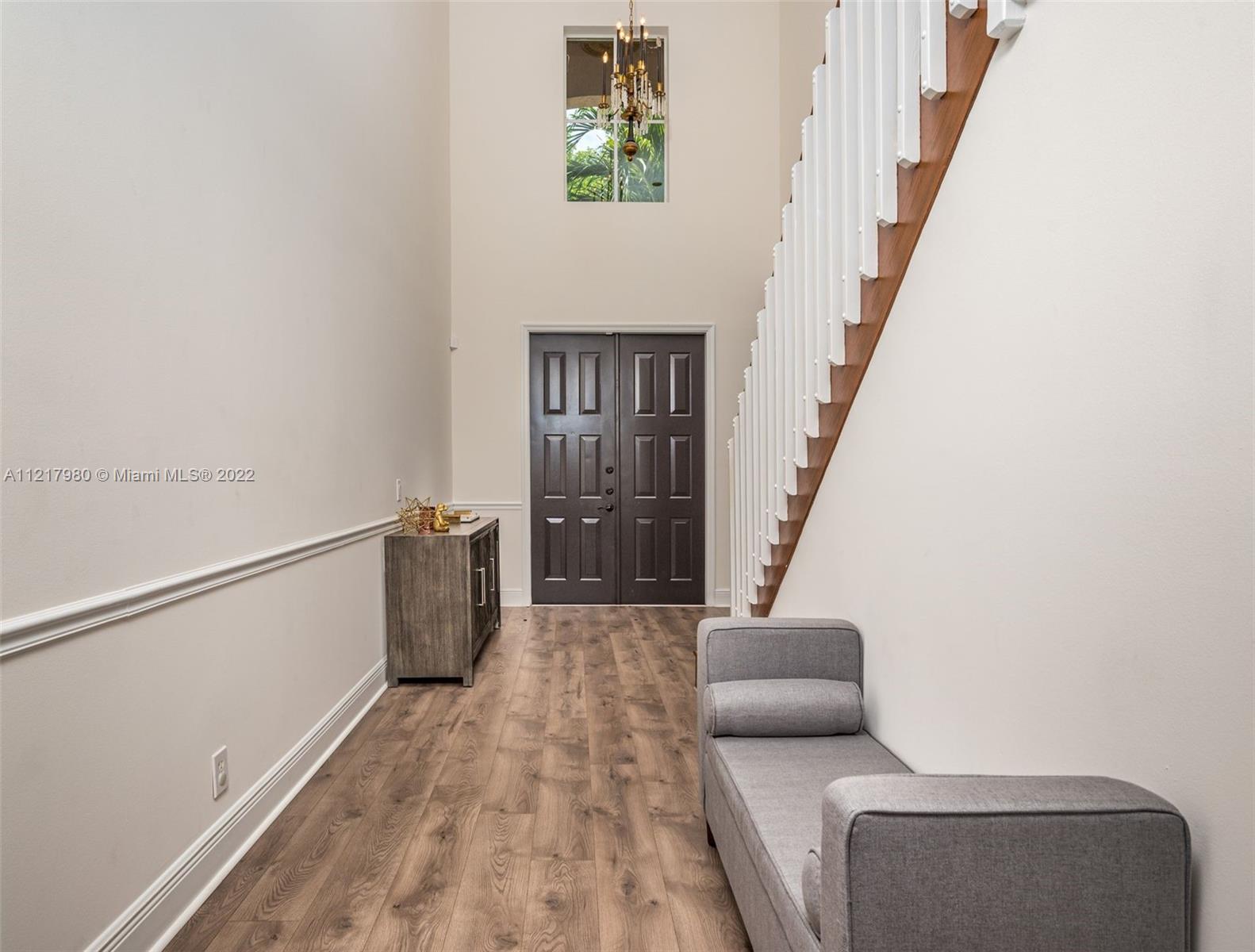 1418 Sandpiper Circle Weston, FL 33327 - Photo 6 of 31 a hallway with stairs and wooden floor
