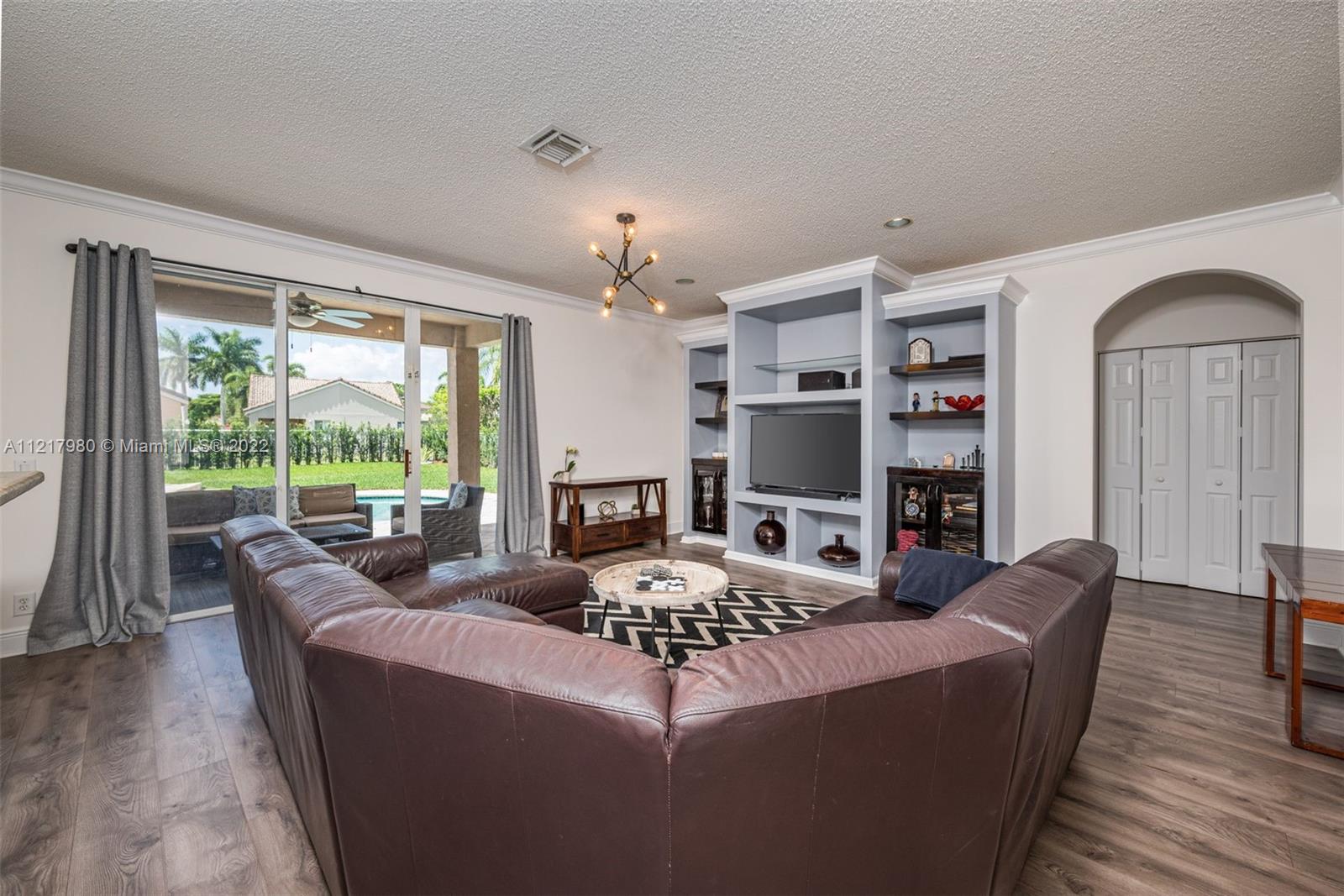 1418 Sandpiper Circle Weston, FL 33327 - Photo 9 of 31 a living room with furniture fireplace and a large window
