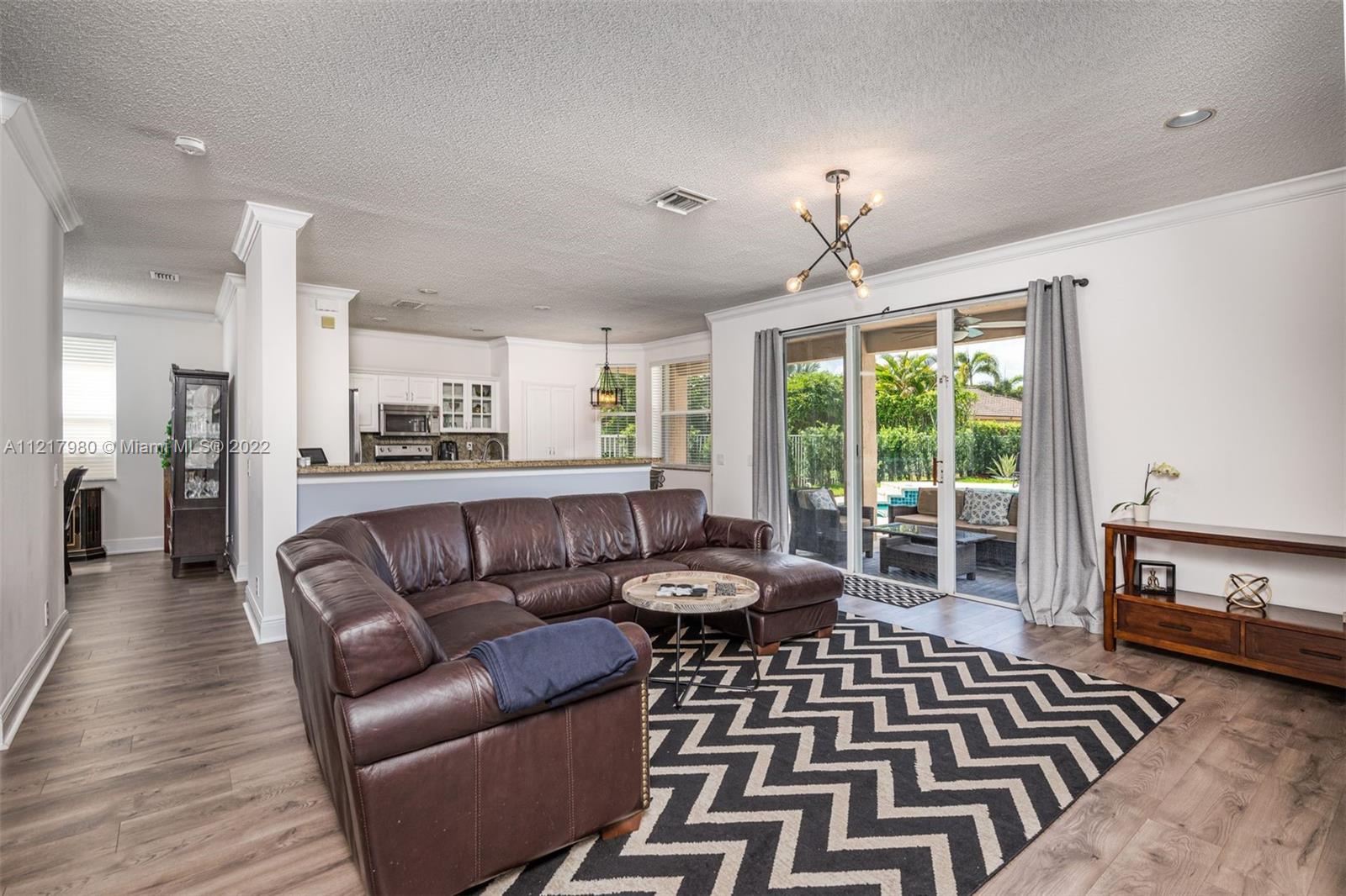 1418 Sandpiper Circle Weston, FL 33327 - Photo 10 of 31 a living room with furniture and a chandelier