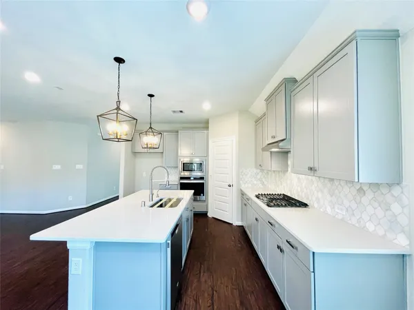a kitchen with kitchen island stainless steel appliances a sink stove and refrigerator