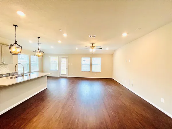 a view of a kitchen with wooden floor and a sink