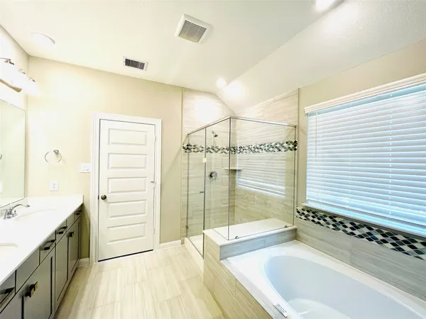 a spacious bathroom with a granite countertop tub a sink and a shower