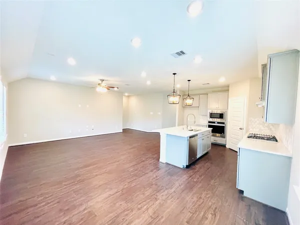 a large kitchen with kitchen island a white counter space a sink stainless steel appliances and cabinets