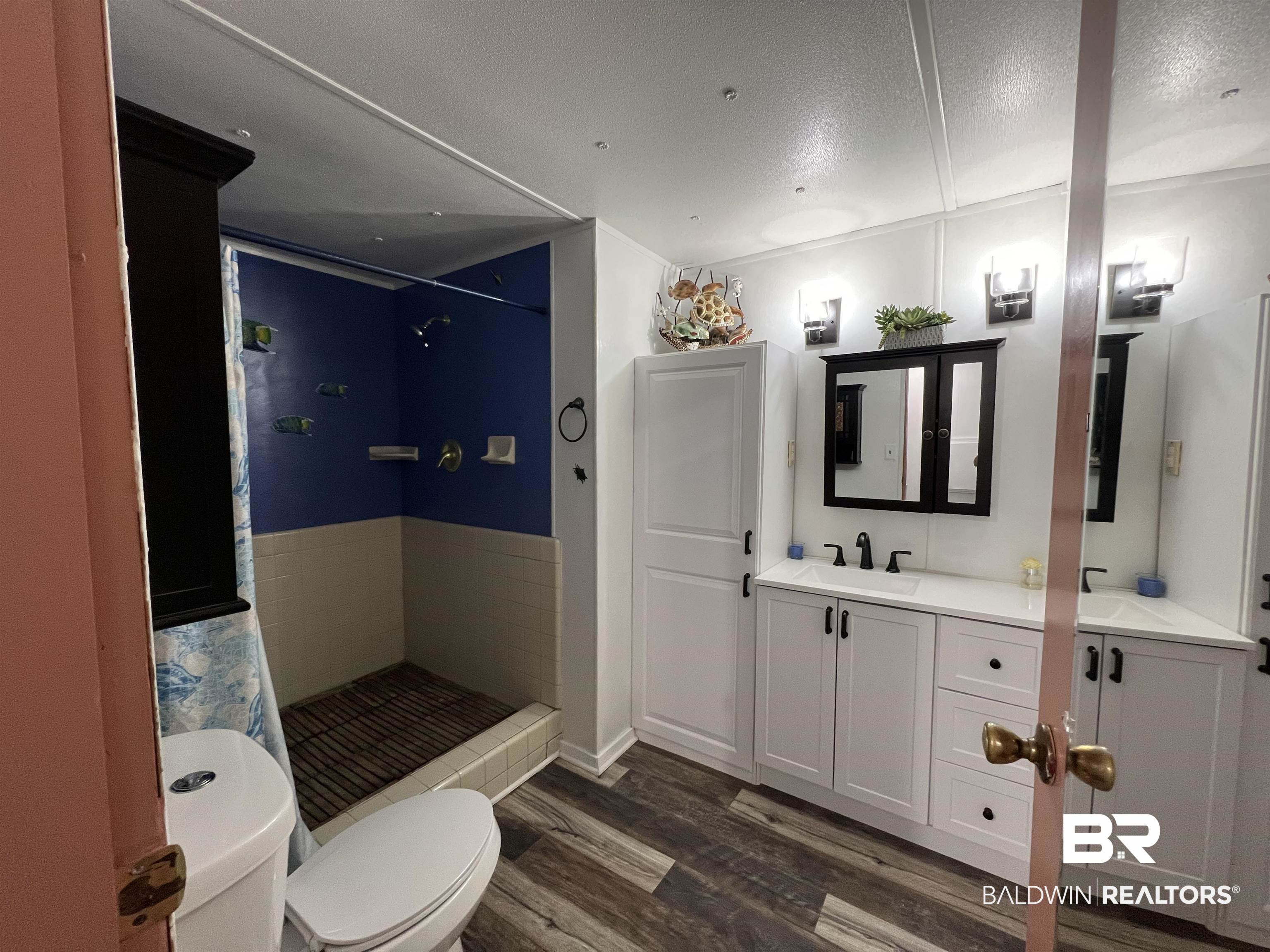 1414 Ridgewood Drive Lillian, AL 36549 - Photo 14 of 26 Bathroom featuring a textured ceiling, vanity, toilet, and hardwood / wood-style floors