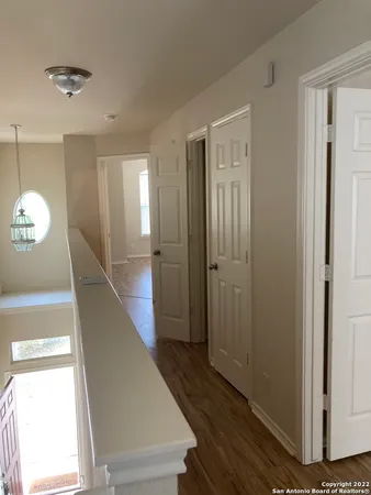 a view of a hallway with wooden floor and staircase
