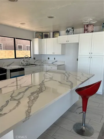 a large kitchen with kitchen island stainless steel appliances a sink and cabinets