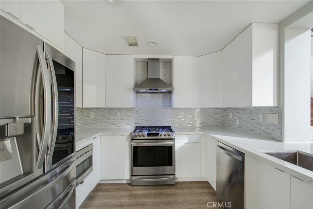 102 Roadrunner Irvine, CA 92603 - Photo 4 of 20 a kitchen with stainless steel appliances granite countertop a stove and a refrigerator