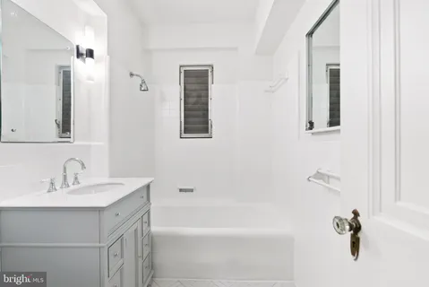 a bathroom with a tub sink and mirror