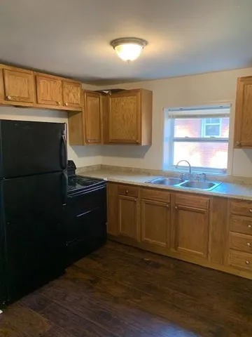 a kitchen with granite countertop a refrigerator and a sink