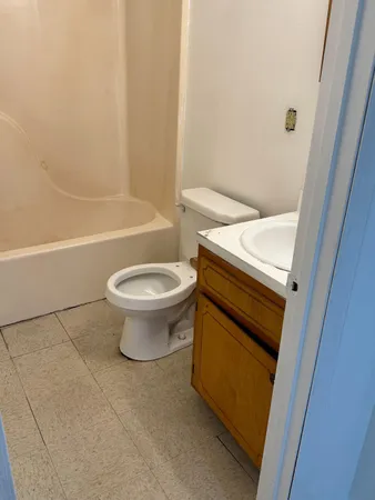 a white toilet sitting next to a bath tub