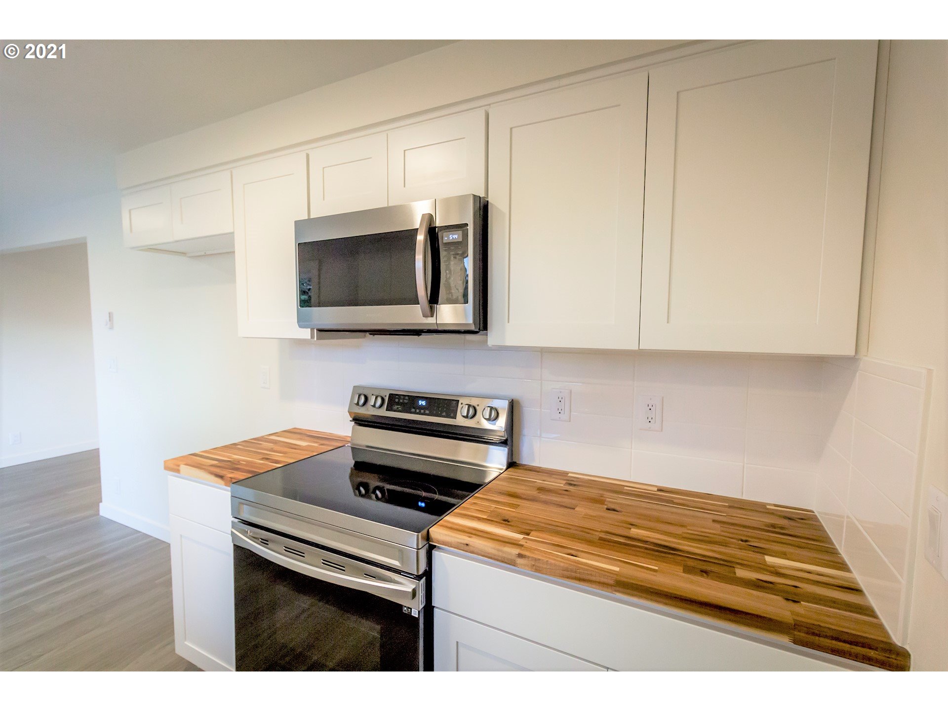 2302 Grovedale Drive Springfield, OR 97477 - Photo 17 of 29 a kitchen with stainless steel appliances a stove a microwave and white cabinets