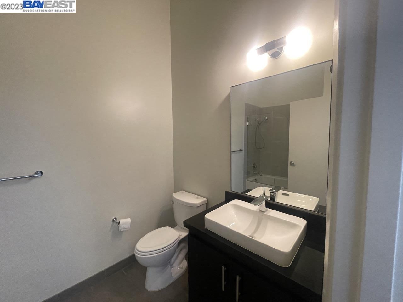 311 2nd Street, Unit 804 Oakland, CA 94607 - Photo 6 of 17 a bathroom with a toilet a sink and mirror