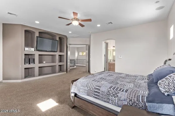a spacious bedroom with a bed and cabinets