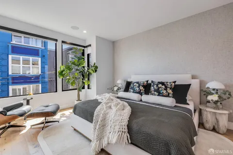 a bedroom with a bed and a painting on the wall