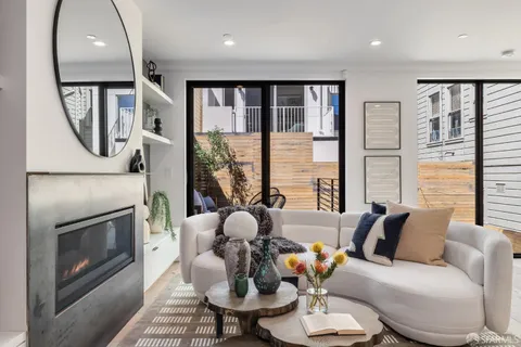 a living room with furniture a mirror and a wooden floor
