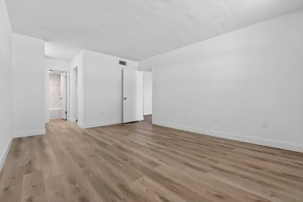 a view of an empty room and wooden floor
