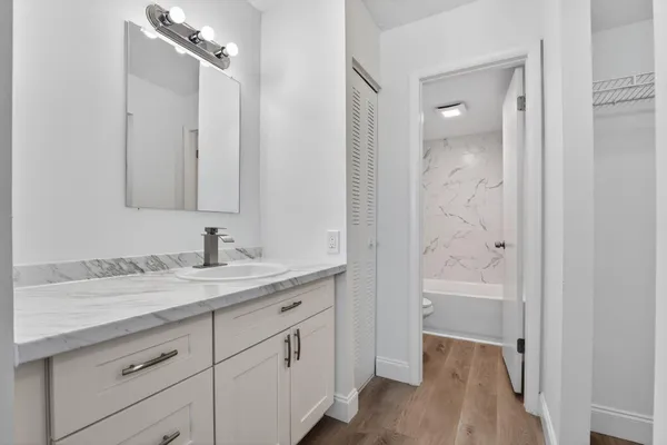 a bathroom with a granite countertop sink tub and a mirror