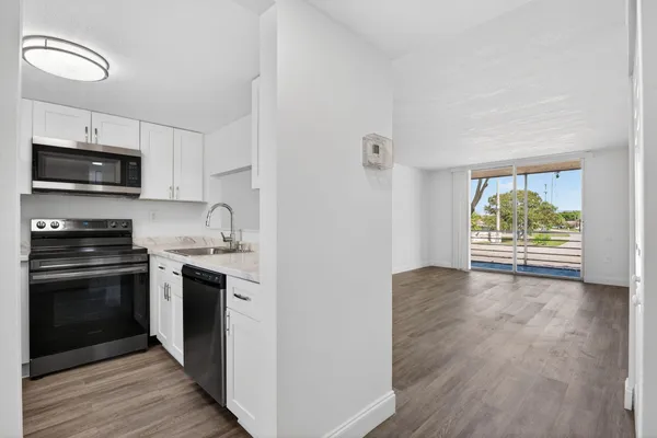 a kitchen with stainless steel appliances a stove microwave and sink