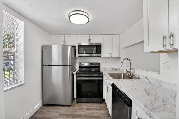 a kitchen with a sink a stove a refrigerator and a window