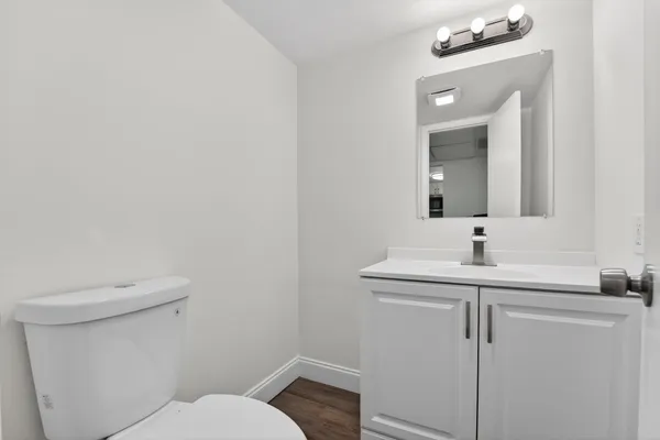 a bathroom with a toilet a sink and mirror