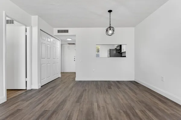 a view of a room with wooden floor and white walls
