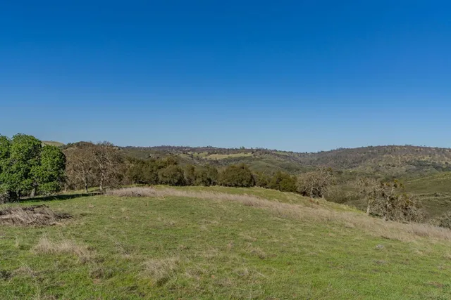 a view of a field with mountains in the background