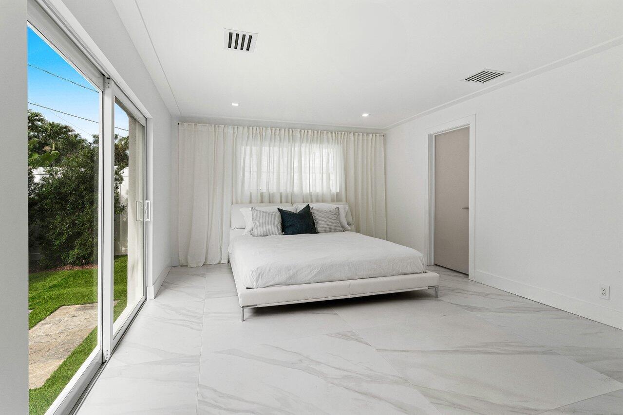 902 Southwest 27th Place Boynton Beach, FL 33435 - Photo 14 of 52 a bedroom with a large bed and a large window