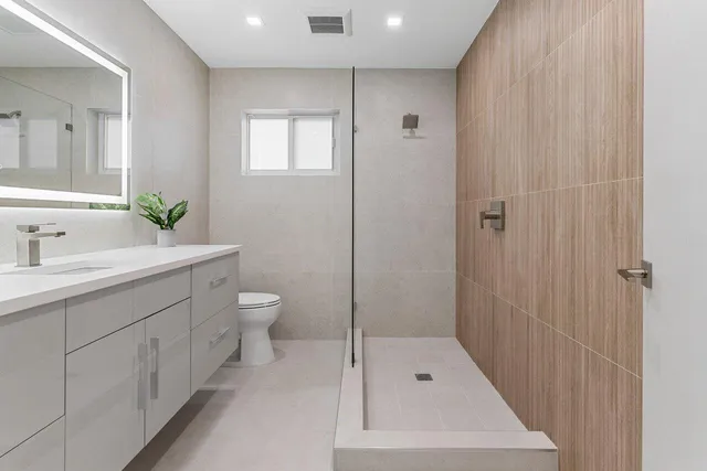 a bathroom with a sink a toilet and shower