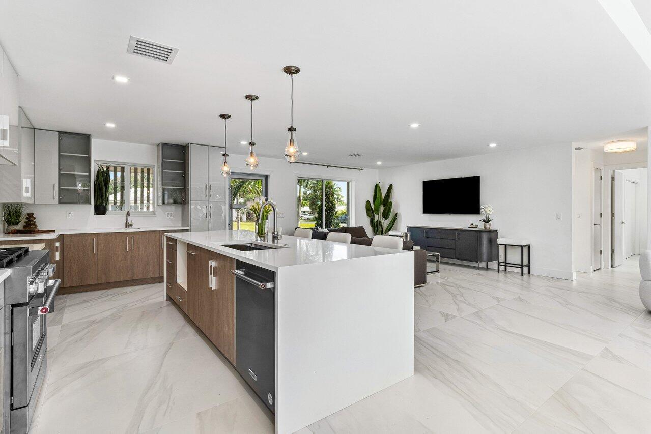 902 Southwest 27th Place Boynton Beach, FL 33435 - Photo 6 of 52 a large kitchen with stainless steel appliances kitchen island granite countertop a large counter top and sink