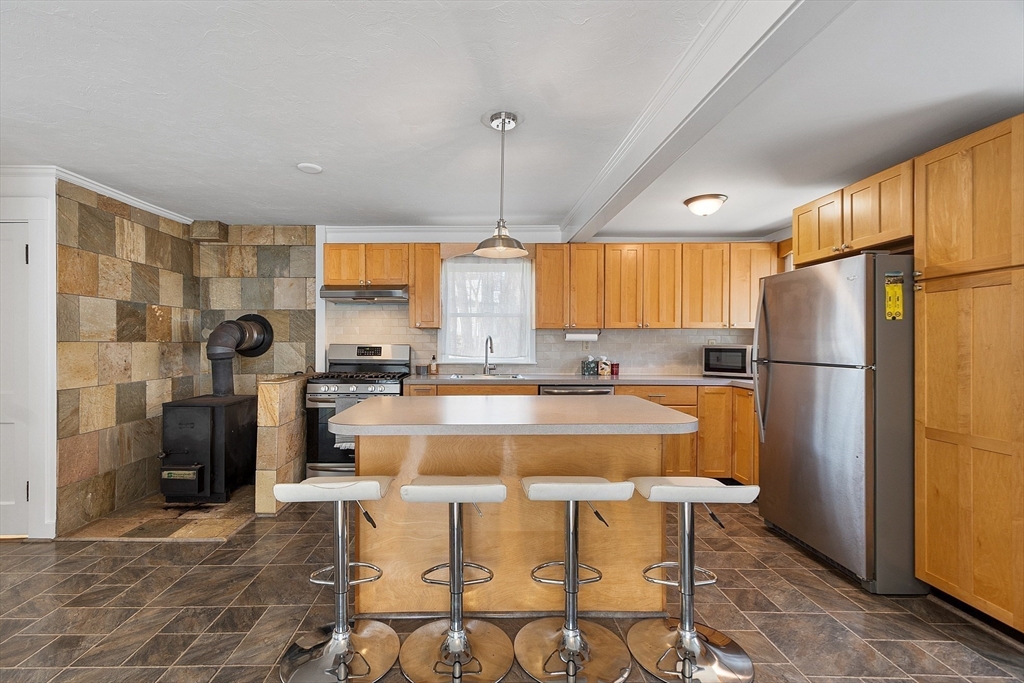 48 Mill Street Maynard, MA 01754 - Photo 11 of 31 a kitchen with a refrigerator a sink dishwasher with a dining table and chairs