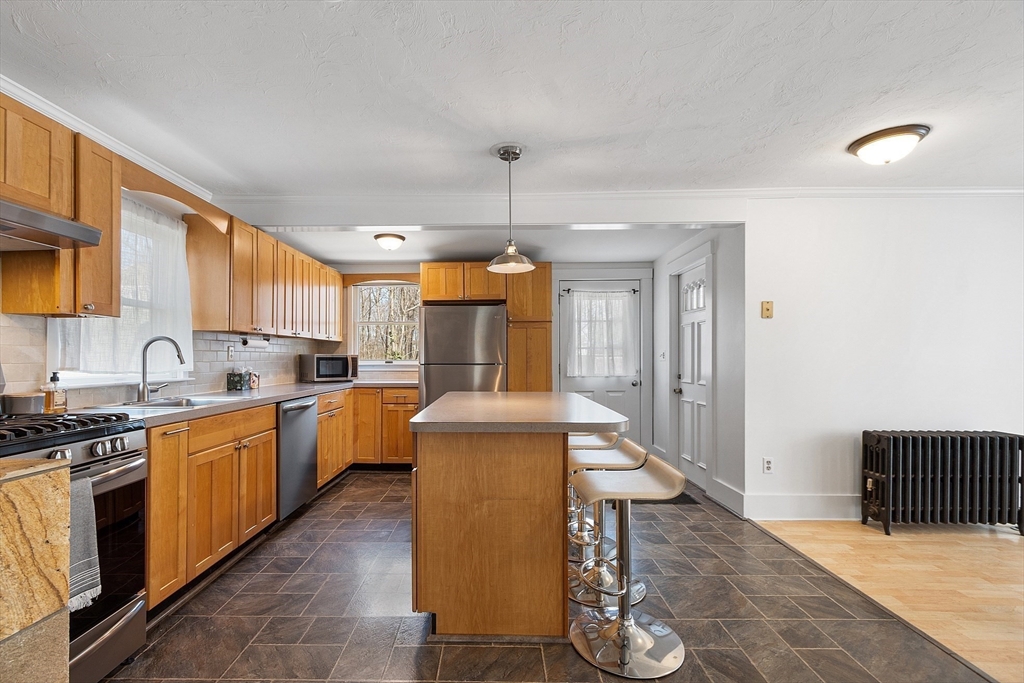 48 Mill Street Maynard, MA 01754 - Photo 5 of 31 a kitchen with granite countertop a stove a sink dishwasher and a refrigerator