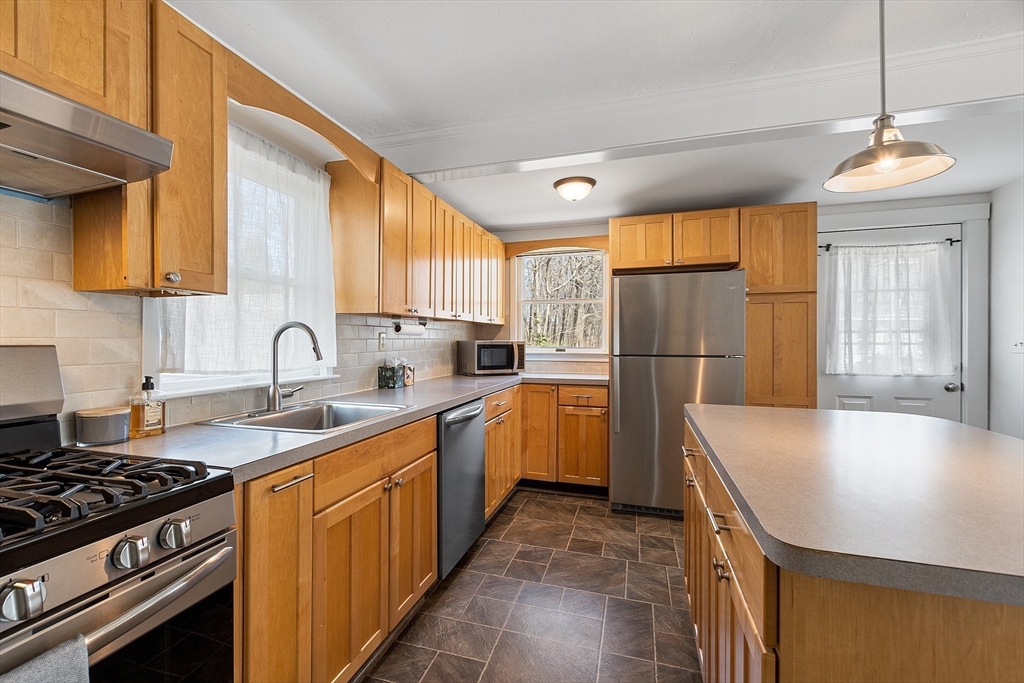 48 Mill Street Maynard, MA 01754 - Photo 9 of 31 a kitchen with granite countertop a sink stainless steel appliances and window