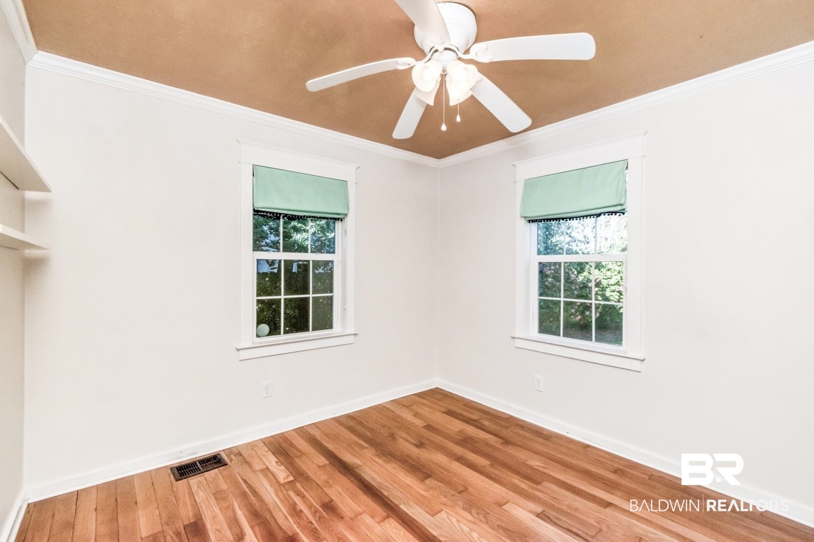 10 South Hathaway Road Mobile, AL 36608 - Photo 22 of 46 Empty room featuring ornamental molding, wood finished floors, healthy amount of natural light, and ceiling fan