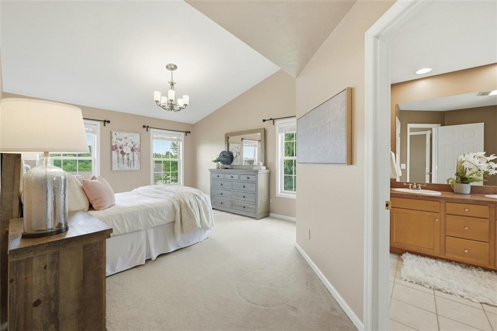 4003 Oak Point Circle McKees Rocks, PA 15136 - Photo 25 of 50 The spacious primary suite features vaulted ceilings, oversized windows, and a calming neutral palette that creates a true retreat feel. Generous proportions provide ample space for both relaxation and additional furniture placement.