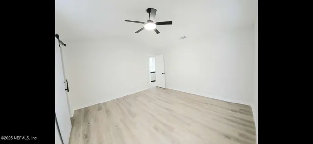 a view of empty room with ceiling fan