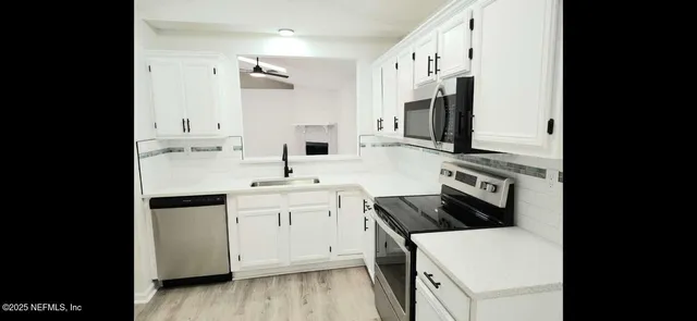 a kitchen with stainless steel appliances a sink stove and refrigerator