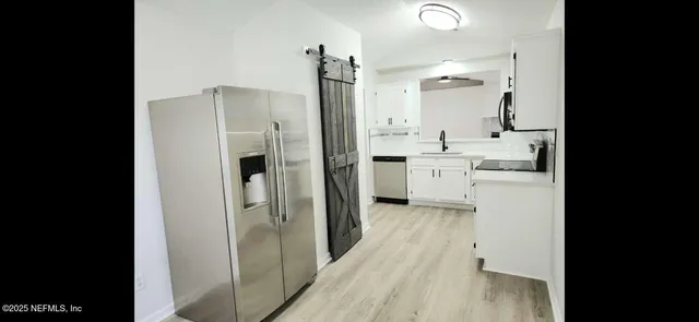 a view of a kitchen from a hallway