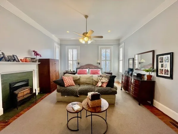 a bedroom with furniture a fireplace and a chandelier
